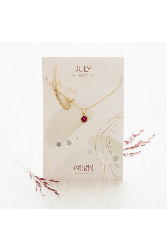 Birthstone necklace by Amano Studio, featuring a faceted gemstone on an 18-inch gold plated brass chain, displayed with crystals and description card.
