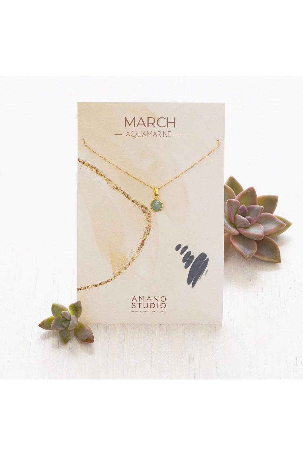 Birthstone necklace by Amano Studio, featuring a faceted gemstone on an 18-inch gold plated brass chain, displayed with crystals and description card.