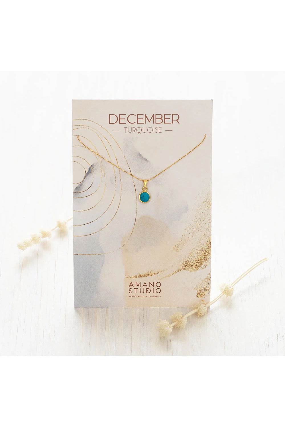 Birthstone necklace by Amano Studio, featuring a faceted gemstone on an 18-inch gold plated brass chain, displayed with crystals and description card.